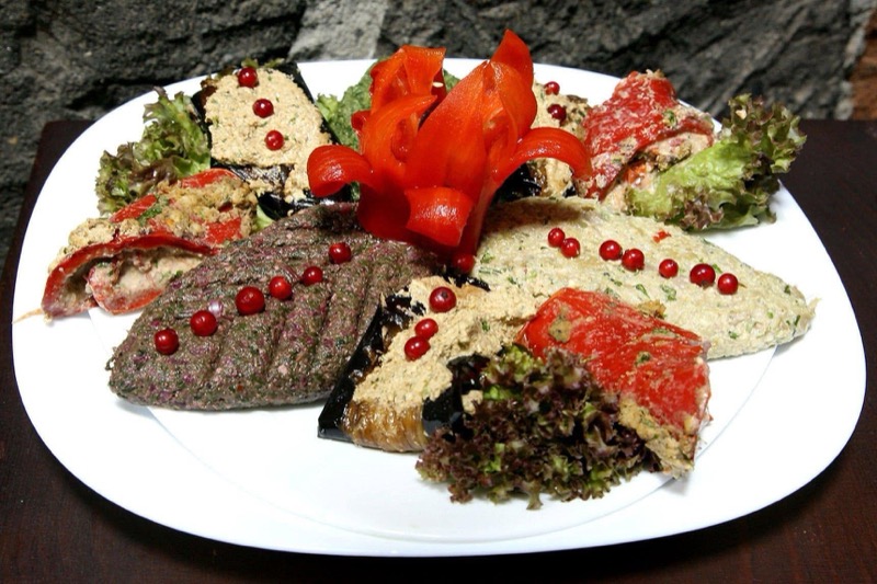 A plate of grilled Georgian food with fresh herbs at a supra