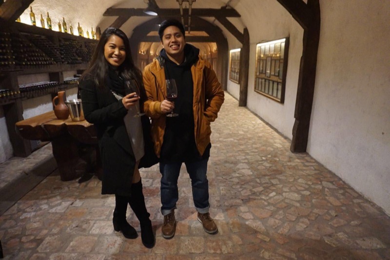 A group tasting wine in a long brick cellar in Kakheti