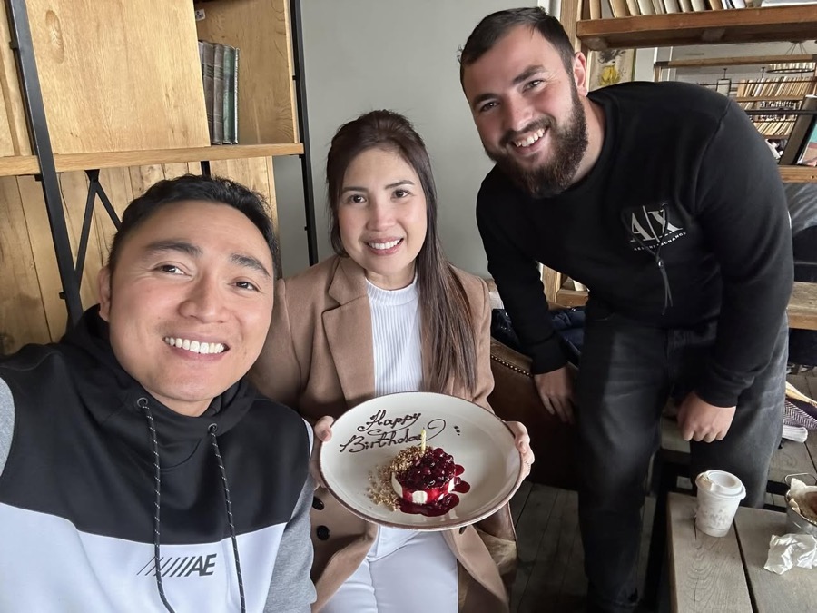 A Georgia by Car couple celebrating a birthday with a cake and their guide in a Tbilisi café