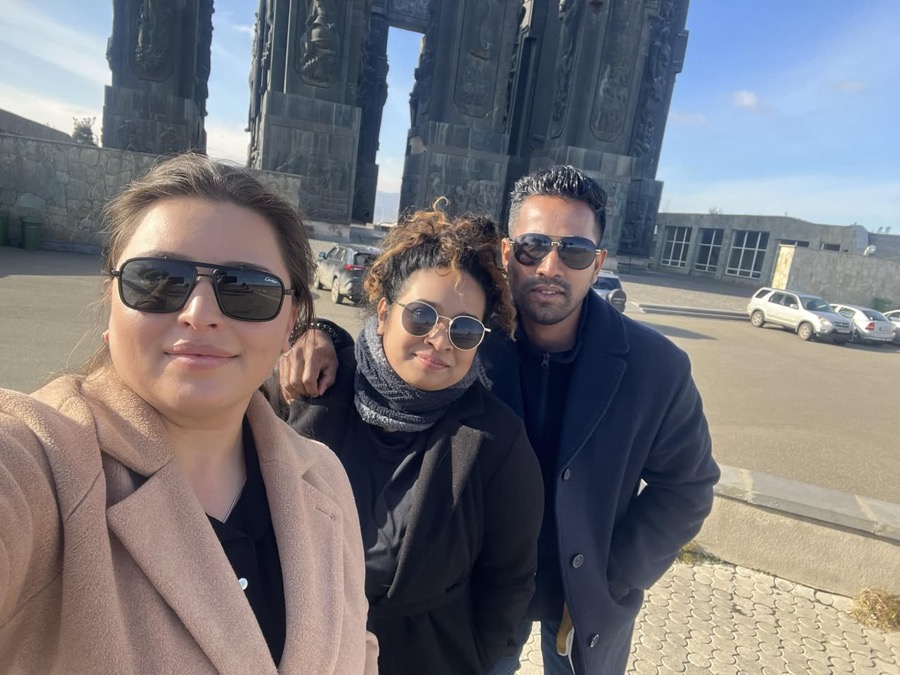 Three Georgia by Car travellers at the Chronicle of Georgia monument above Tbilisi on a clear winter day