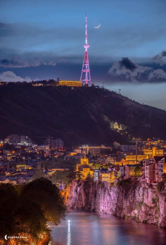 Tbilisi at dusk with the television tower on Mtatsminda above the lit city