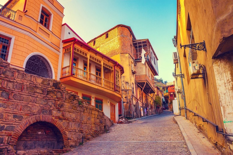 A cobbled Old Town street lined with carved wooden balconies in Tbilisi